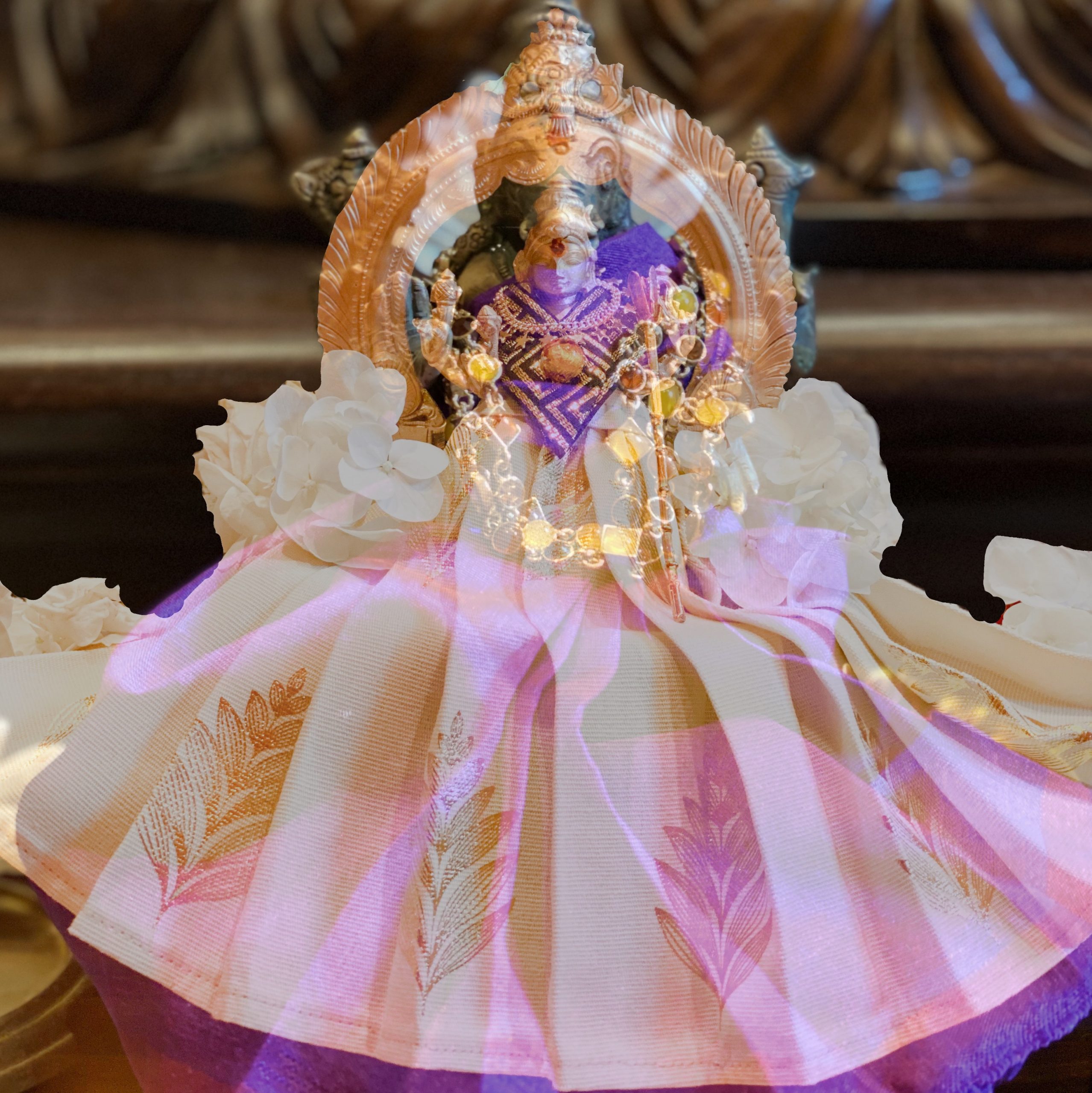 FullSizeRender A home shrine murti of the Goddess dressed in a pink and gold sari with white flowers and crystal garlands