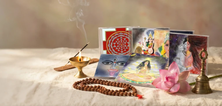 An altar set with japa beads, a lamp, framed pictures of the deities and flowers