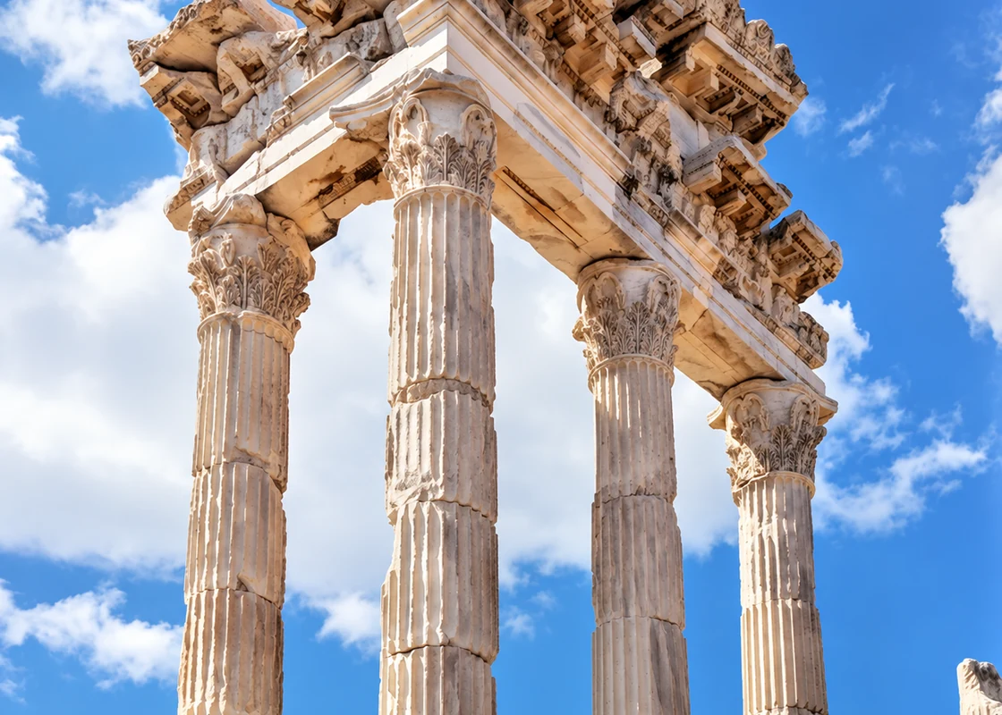 Corinthian columns of a ruined temple standing against an open blue sky